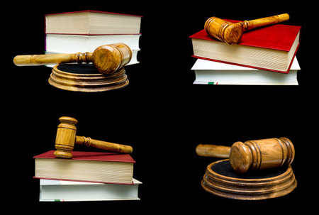 Wooden judge hammer and book on a black background. Horizontal photo.