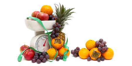Kitchen scales, fruits and measuring tape on a whiteの写真素材