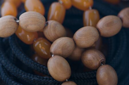 Rosary wood and amber on the background of the rope close-up photoの写真素材