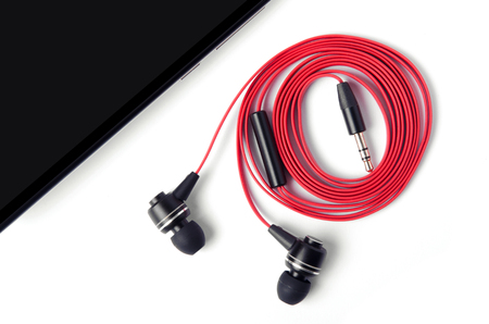 mobile phone and red headphones on a white background isolationの写真素材