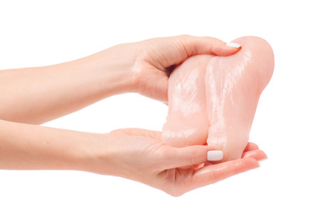 Chicken breast fillets in a hand on a white background isolation