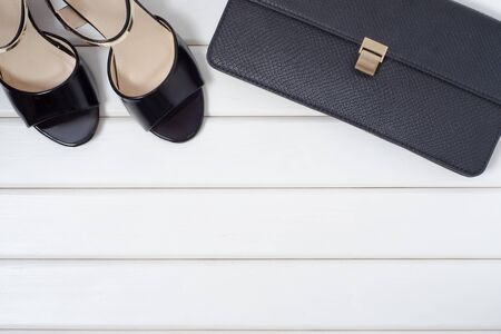 Women's shoes and bag clutch on a white wooden backgroundの写真素材