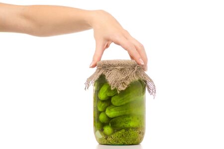 Preservation of a bank of cucumbers female hand on a white background isolationの写真素材
