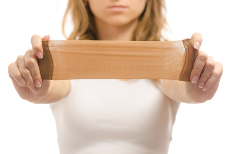 Female hands with nylon socks den on a white background isolationの写真素材