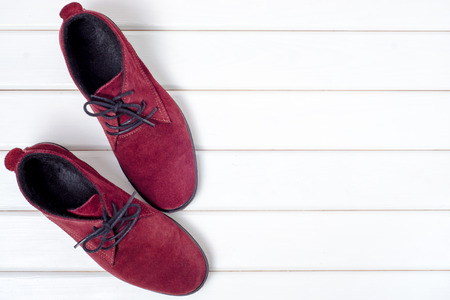 Bordeaux suede female shoes on a white wooden backgroundの写真素材
