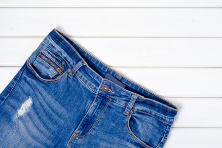 Blue jeans on a white wooden backgroundの写真素材
