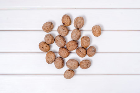 Walnuts whole on a white wooden background