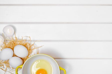 Eggs yolk in a plate on a white wooden backgroundの写真素材