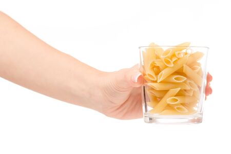 Female hand holding a glass of pasta on a white background isolationの写真素材