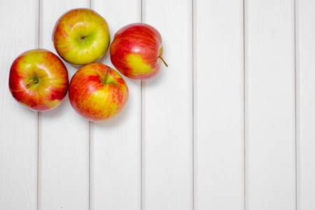 Red beautiful apples on a white wooden backgroundの写真素材