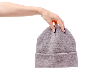 Warm hat gray in female hands on a white backgroundの写真素材