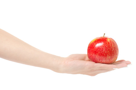 Female hand holding a red apple on a white background isolationの写真素材