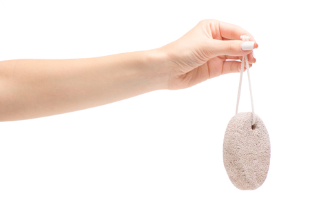 Female hands with stone for legs grater on white background isolationの写真素材