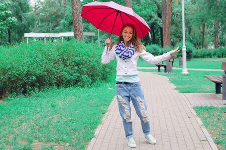 Beautiful young woman on nature park umbrella dripping rainの写真素材