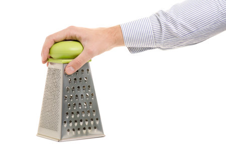 Man's hand with a kitchen grater on a white background isolation