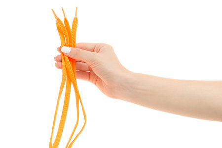 Female hands bright orange shoelaces on a white background isolation