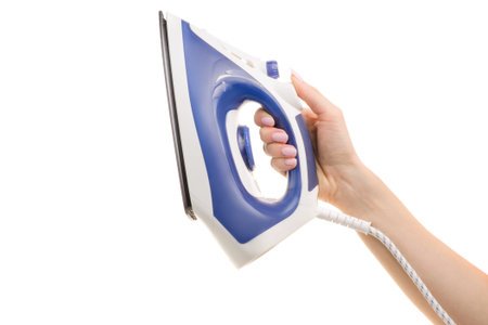 Iron in a female hand on a white background isolationの写真素材