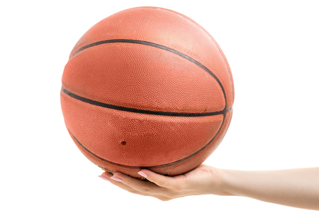 Basketball in a female hand on a white background isolationの写真素材