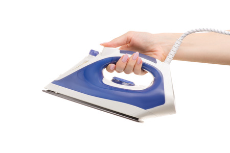 Iron in a female hand on a white background isolationの写真素材