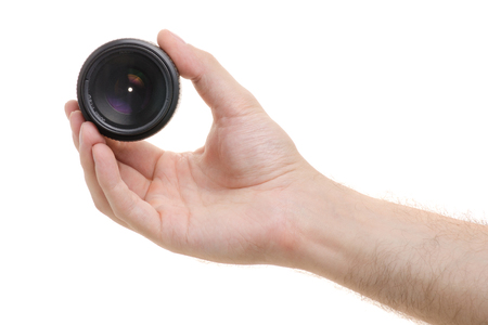 Lens on a camera in a male hand on a white background isolationの写真素材
