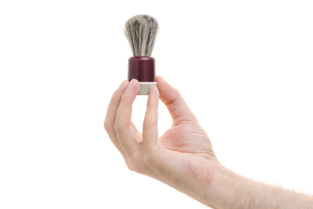 Shaving brush in a male hand on a white background isolationの写真素材