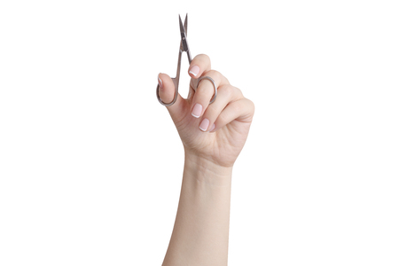 Manicure scissors in hands on a white background isolationの写真素材