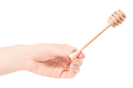 Spoon for honey in hand on a white background isolationの写真素材