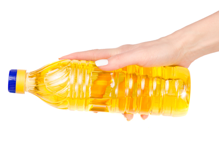 Bottle of sunflower oil in a hand on a white background isolationの写真素材