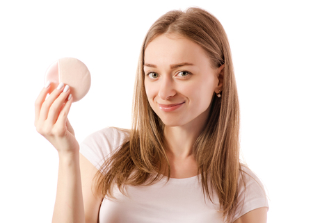 Beautiful young woman in the hands of a cosmetic sponge on a white background isolationの写真素材