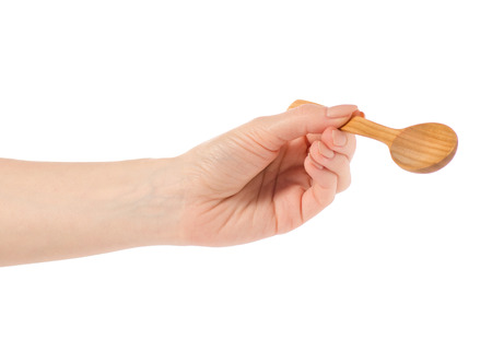 Wooden small spoon in hand on white background isolationの写真素材