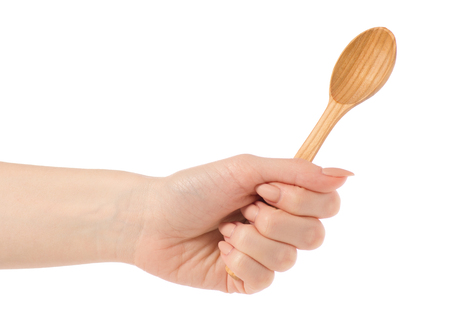 Wooden small spoon in hand on white background isolationの写真素材