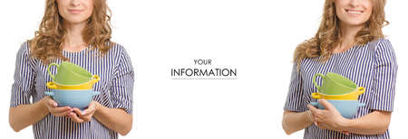 Beautiful young woman set plates in hands kitchen food set pattern on a white background isolationの写真素材