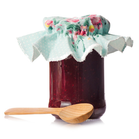 Raspberry jam in a jar wooden spoon on white background isolationの写真素材