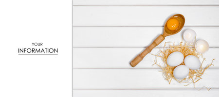 Eggs wooden spoon yolk female hand pattern on a white wooden backgroundの写真素材