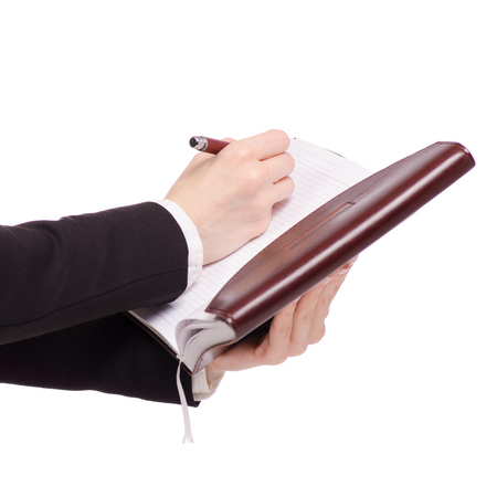 A pen and diary in female hand business woman on white background isolationの写真素材