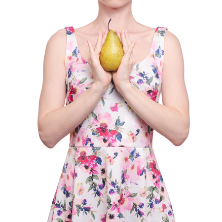 Woman in a dress floral print in the hands fruit pear on white background isolationの写真素材