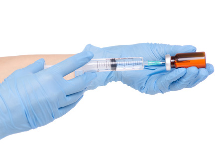 Syringe and medical ampoule in hand medical gloves on white background isolationの写真素材