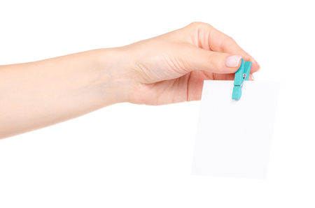 The colorful stationery clothespins with paper for notes in hand on white background isolationの写真素材