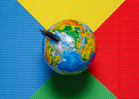 Globe travel on a multi-colored red blue green yellow backgroundの写真素材