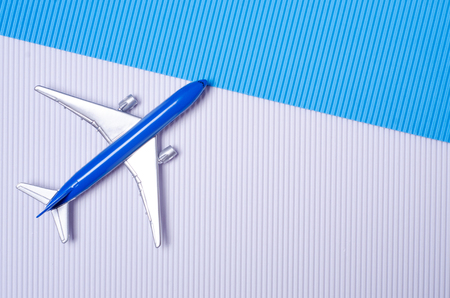 Miniature airplane travel on blue white backgroundの写真素材