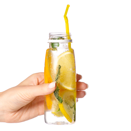 Bottle lemonade lemon orange with mint in hand on white background isolationの写真素材