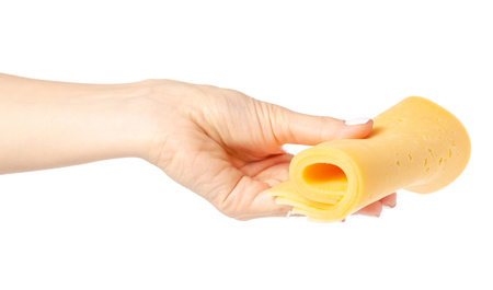 A slice of cheese in a hand on a white background isolationの写真素材