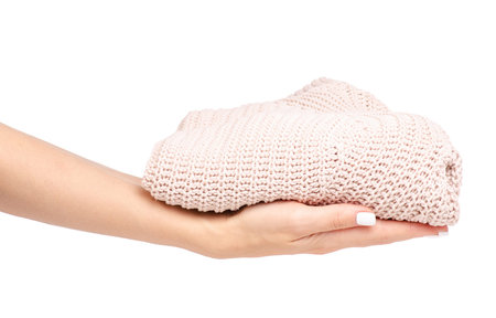 Female beige sweater in hand on white background isolationの写真素材