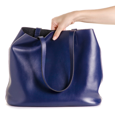 Blue leather female bag in hand on white background isolationの写真素材