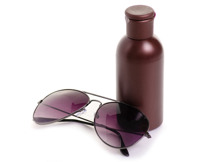 Bottle of suntan oil sunglasses on white background isolationの写真素材