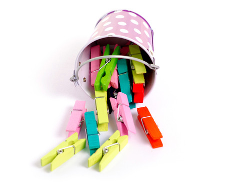 A small bucket with clothespins on a white background isolationの写真素材