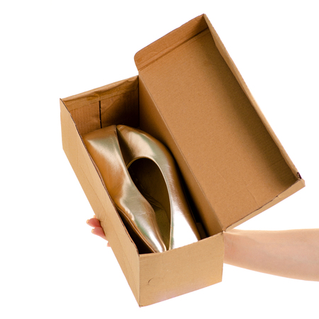 Female shoes in a box in a hand on a white background isolationの写真素材