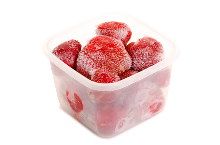 Frozen strawberries in a container on a white background isolationの写真素材