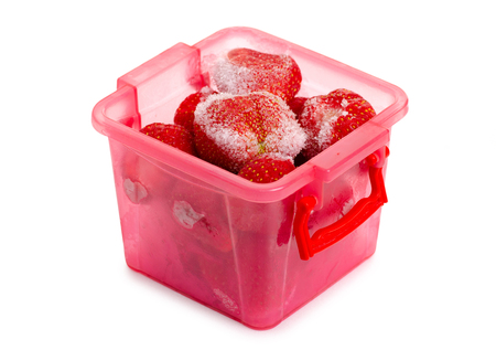 Frozen strawberries in a container on a white background isolationの写真素材