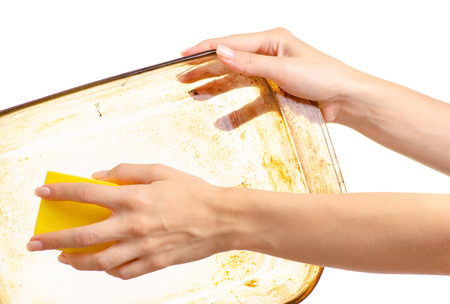 A woman is washing greasy dirty glass dishes with a kitchen sponge on white background isolationの写真素材